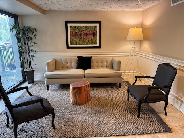 interior space featuring light tile patterned flooring and a paneled ceiling