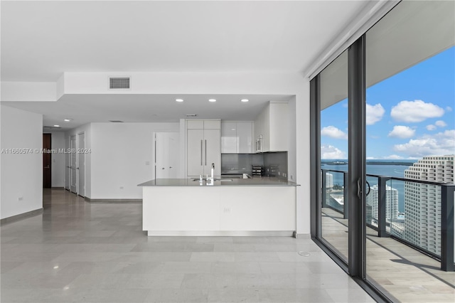 kitchen featuring white cabinets, sink, tasteful backsplash, stainless steel appliances, and a water view