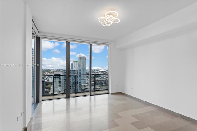 unfurnished room featuring a wall of windows