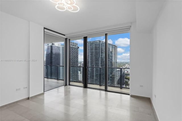68 SE 6th St Unit 3102, Miami, FL 33131 - empty room featuring plenty of natural light, a wall of windows, baseboards, and a city view