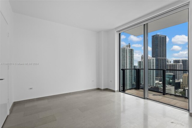 68 SE 6th St Unit 3102, Miami, FL 33131 - empty room with expansive windows, a view of skyline, and baseboards