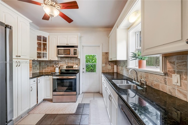 kitchen featuring decorative backsplash, stainless steel appliances, white cabinetry, and ceiling fan