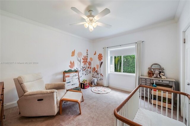 bedroom with a crib, carpet floors, crown molding, and ceiling fan