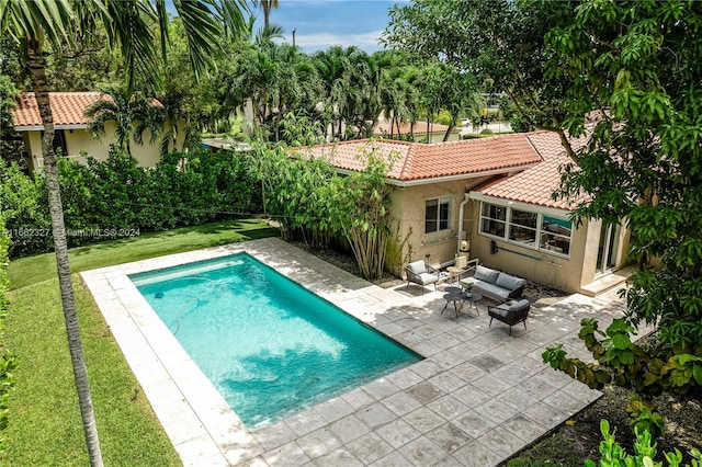 view of pool featuring outdoor lounge area, a lawn, and a patio area