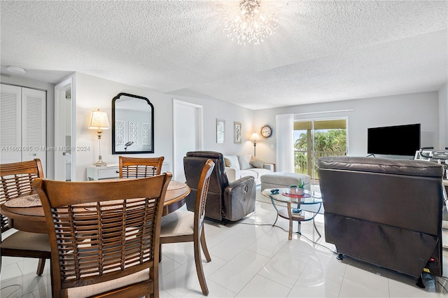 dining area featuring an inviting chandelier, a textured ceiling, and light tile patterned flooring