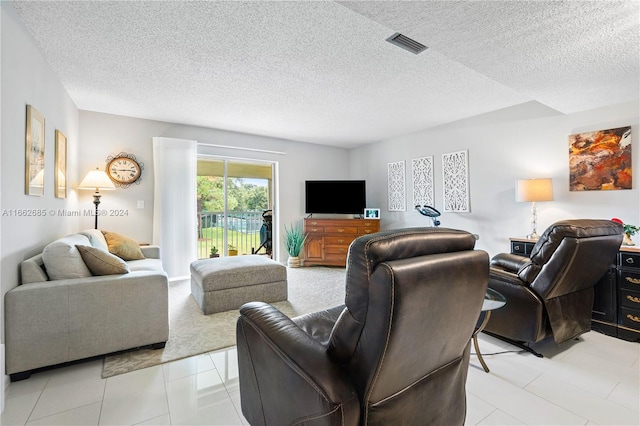 tiled living room featuring a textured ceiling