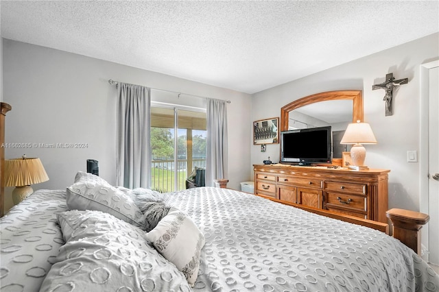 bedroom featuring a textured ceiling and access to exterior