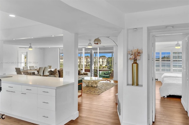 kitchen featuring ceiling fan, white cabinets, and light hardwood / wood-style floors