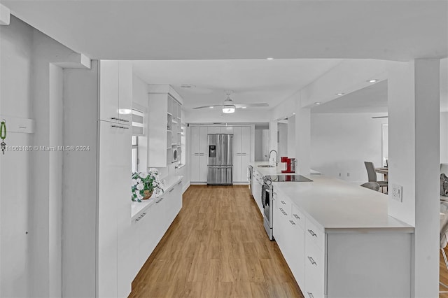 kitchen with ceiling fan, white cabinets, sink, light hardwood / wood-style flooring, and stainless steel appliances