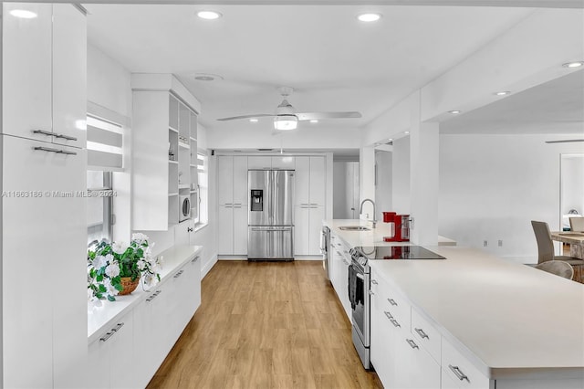 kitchen featuring light wood-type flooring, white cabinetry, ceiling fan, and appliances with stainless steel finishes