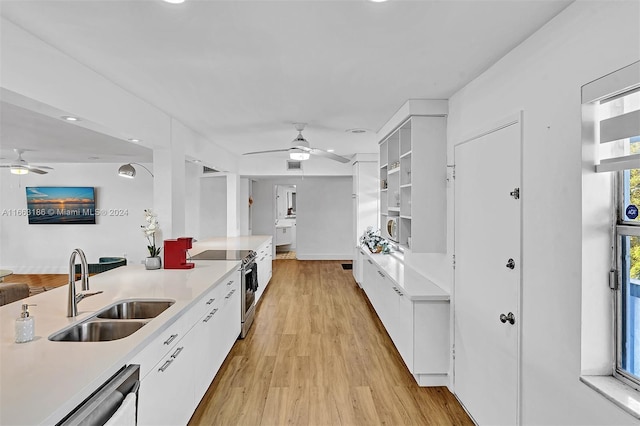 kitchen featuring white cabinets, stainless steel electric range, ceiling fan, and sink