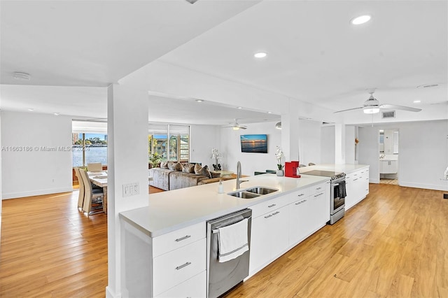 kitchen with ceiling fan, sink, white cabinetry, appliances with stainless steel finishes, and light wood-type flooring