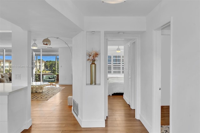 corridor with light hardwood / wood-style floors