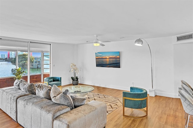 living room featuring light wood-type flooring and ceiling fan