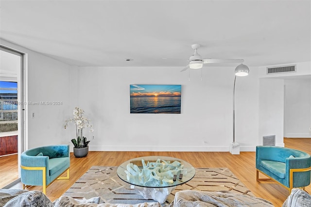 living room with wood-type flooring and ceiling fan