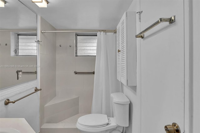 bathroom with a shower with shower curtain, plenty of natural light, vanity, and toilet