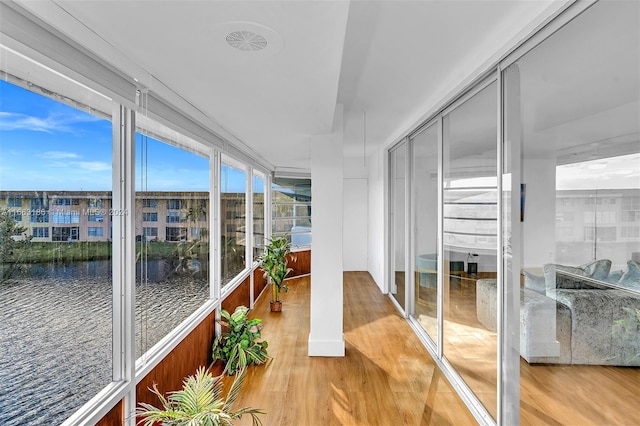 sunroom featuring a water view