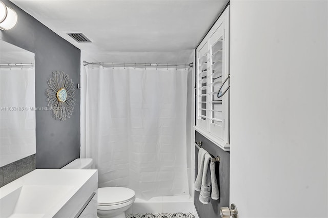 bathroom with curtained shower, vanity, and toilet