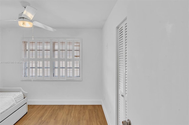 unfurnished bedroom with ceiling fan, light wood-type flooring, and a closet