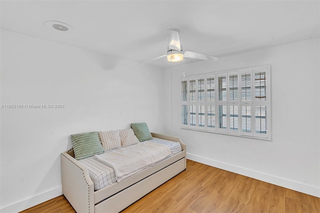 living area with wood-type flooring and ceiling fan