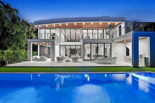 rear view of property with a patio, a balcony, ceiling fan, and an outdoor hangout area