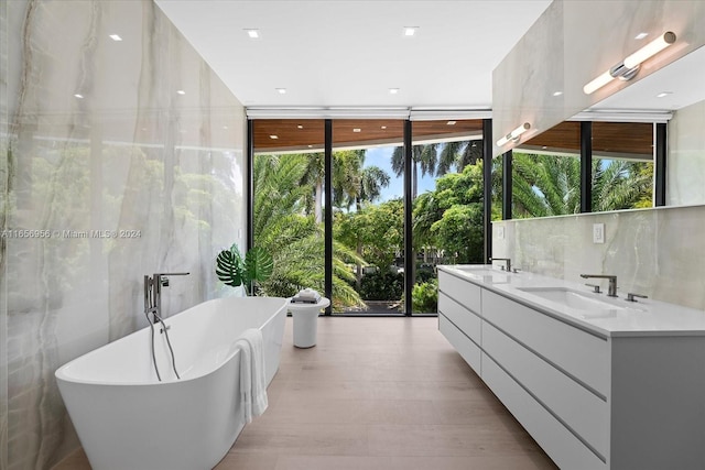 bathroom with decorative backsplash, wood-type flooring, a bath, and vanity