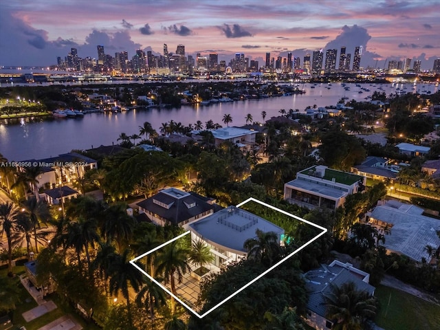 aerial view at dusk featuring a water view