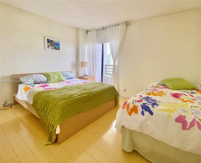 bedroom featuring a textured ceiling and light hardwood / wood-style floors