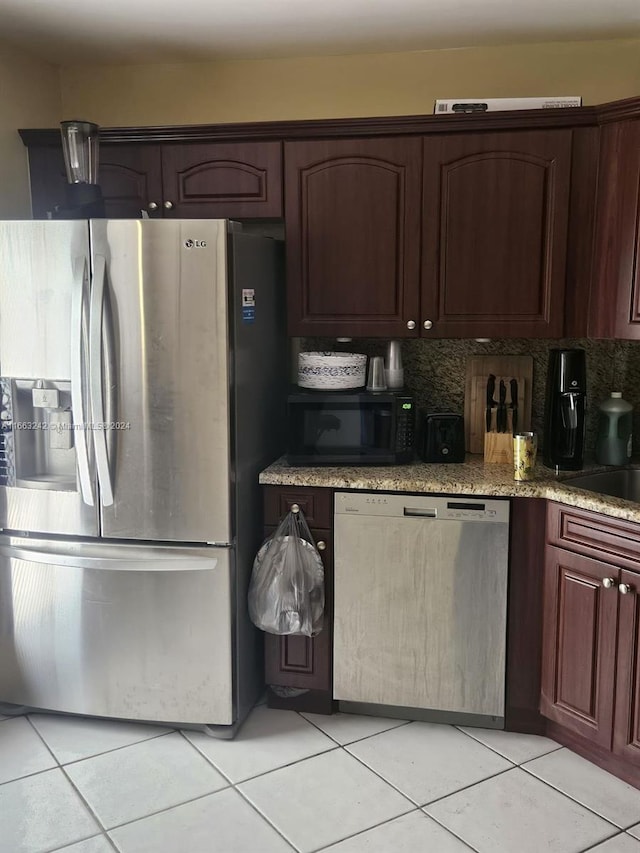 kitchen featuring decorative backsplash, dark brown cabinets, appliances with stainless steel finishes, and light tile patterned flooring