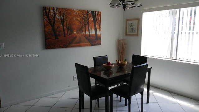 dining space featuring light tile patterned flooring and an inviting chandelier