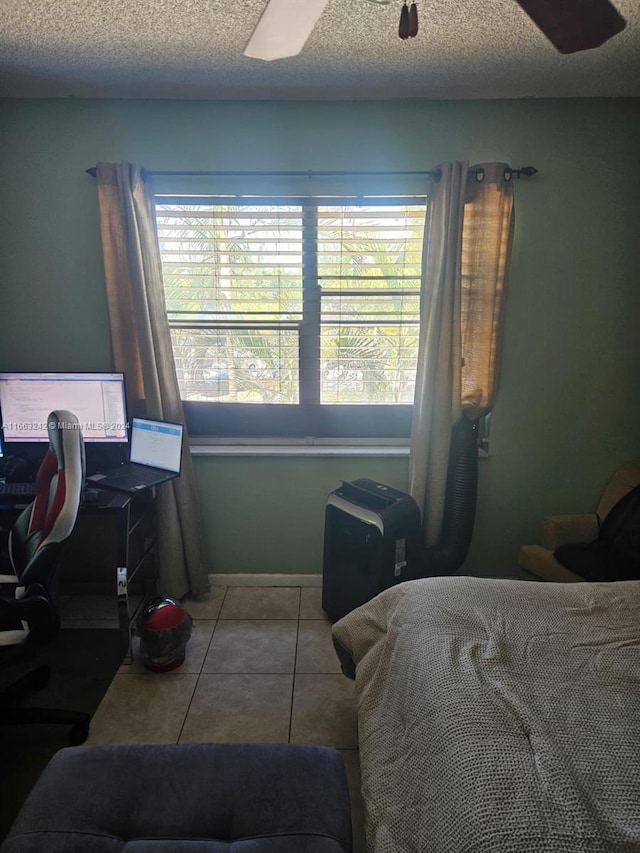 tiled bedroom featuring multiple windows, a textured ceiling, and ceiling fan