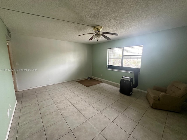 tiled spare room with ceiling fan and a textured ceiling