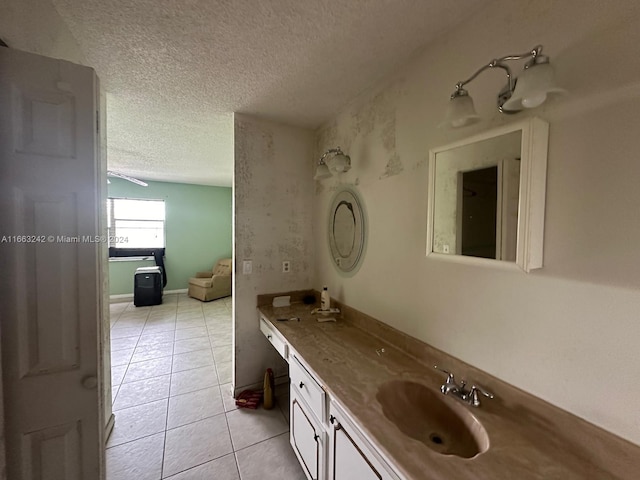 bathroom with tile patterned flooring, a textured ceiling, and vanity