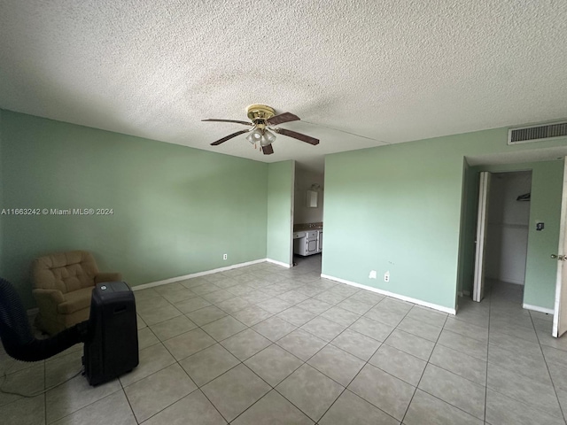 unfurnished room featuring ceiling fan, a textured ceiling, and light tile patterned floors