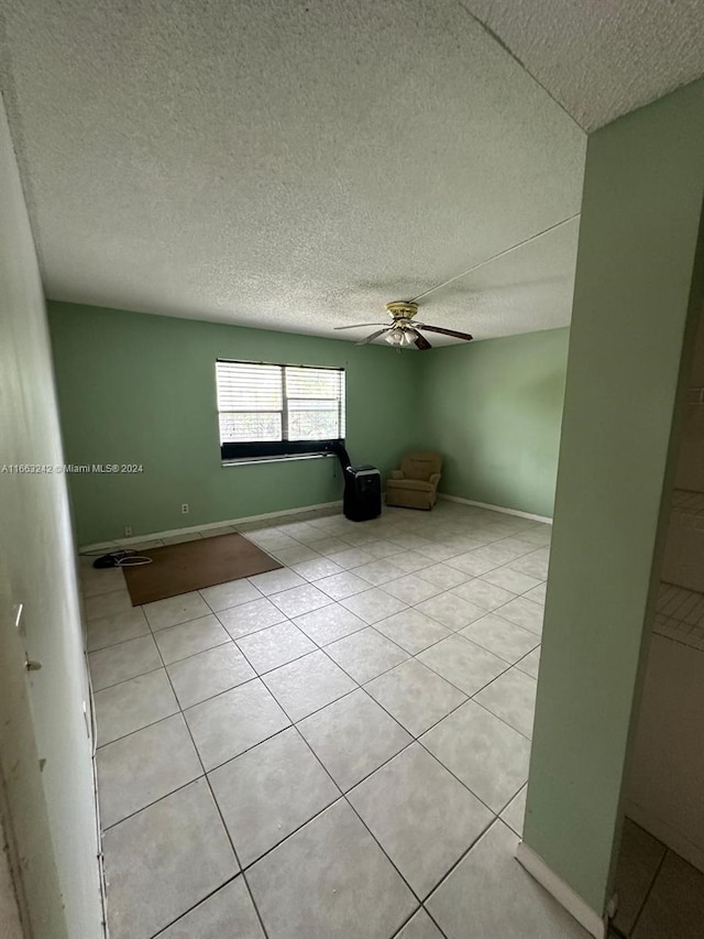 tiled spare room with ceiling fan and a textured ceiling