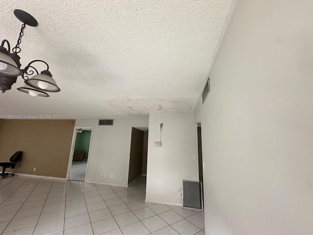 unfurnished room with a textured ceiling and light tile patterned floors