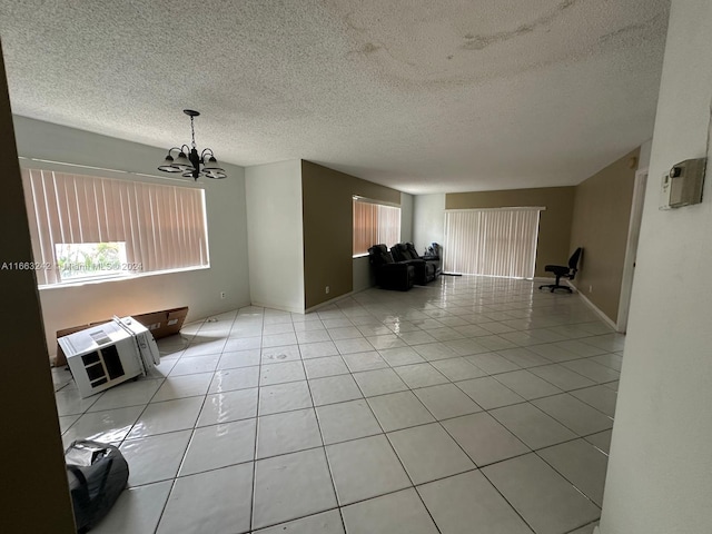 unfurnished living room featuring a notable chandelier, heating unit, a textured ceiling, and light tile patterned floors