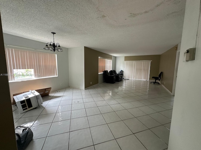 unfurnished living room featuring a textured ceiling, light tile patterned floors, and a chandelier