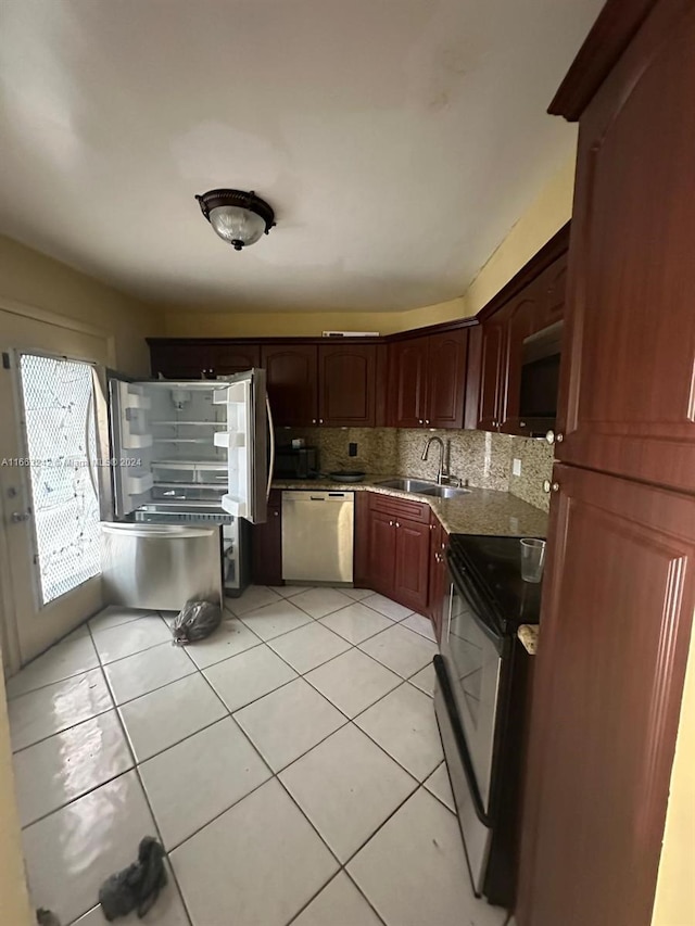 kitchen with light tile patterned flooring, stainless steel appliances, sink, and decorative backsplash