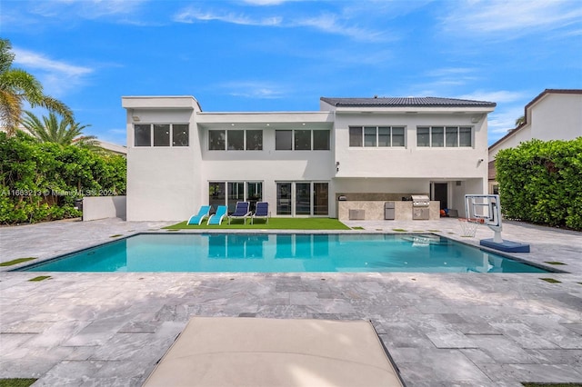 back of property featuring exterior kitchen and a patio