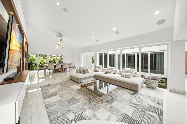 living room with an inviting chandelier and high vaulted ceiling