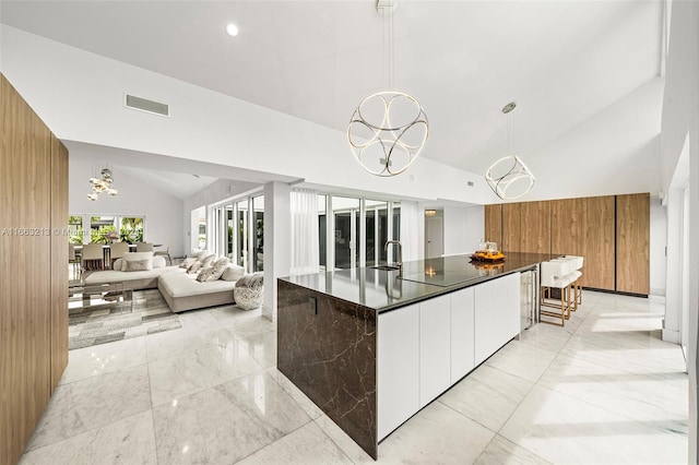 kitchen featuring pendant lighting, a notable chandelier, a large island, and white cabinetry