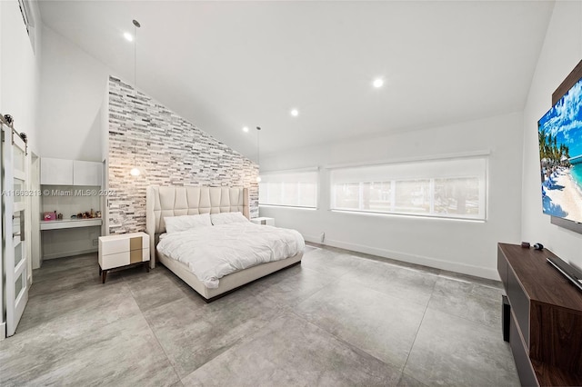 bedroom with a barn door and high vaulted ceiling