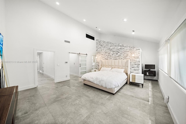 bedroom featuring a barn door and high vaulted ceiling