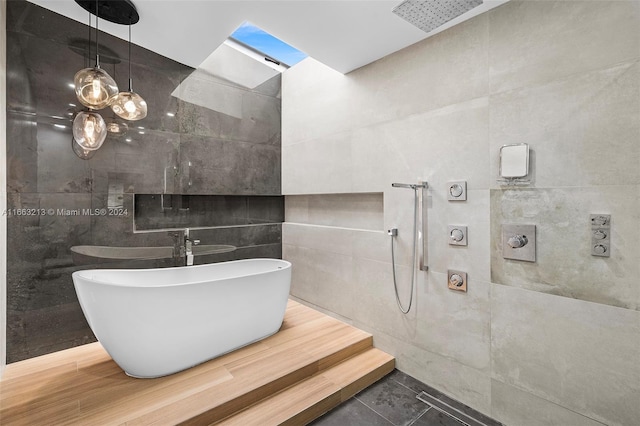 bathroom featuring shower with separate bathtub and tile walls