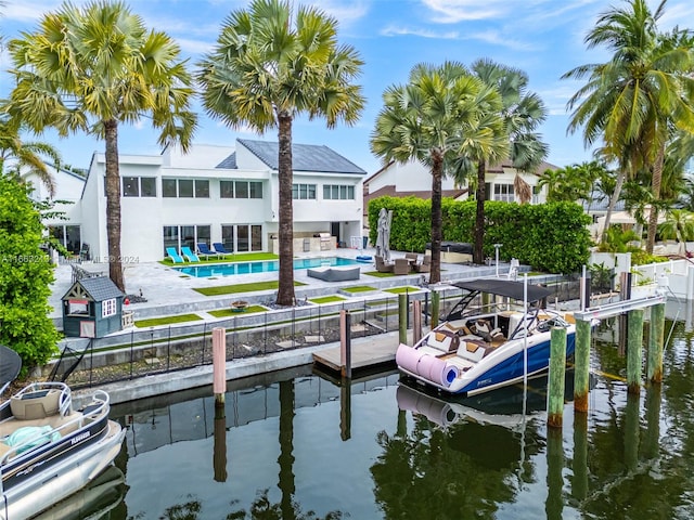 dock area with a water view, a fenced in pool, and a patio area