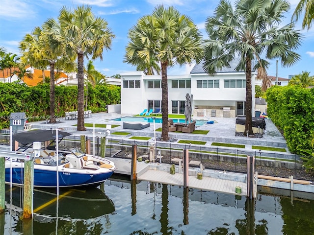 view of dock with a fenced in pool, a water view, and a patio area