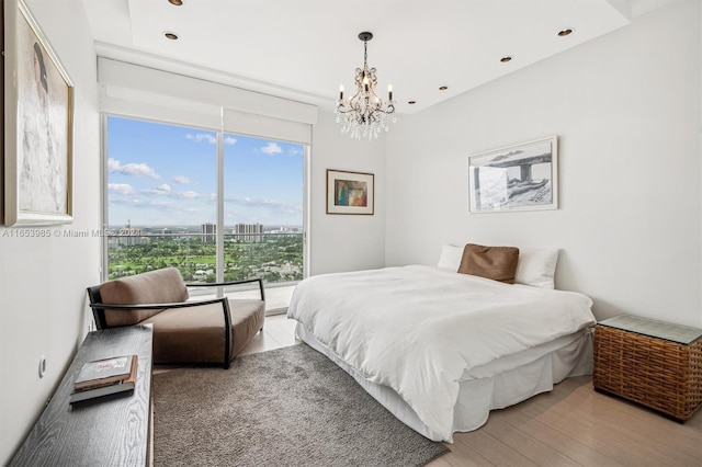 bedroom featuring an inviting chandelier and light hardwood / wood-style flooring