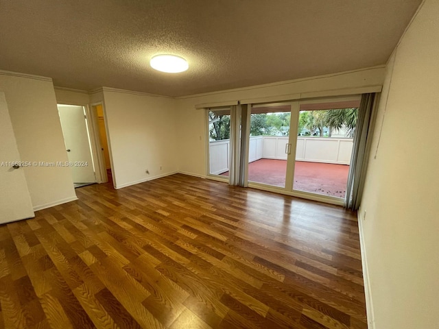 unfurnished room with wood-type flooring and a textured ceiling