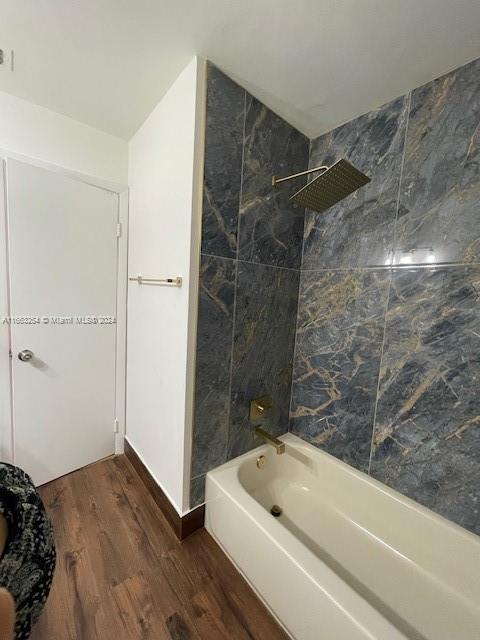 bathroom with tiled shower / bath and hardwood / wood-style floors